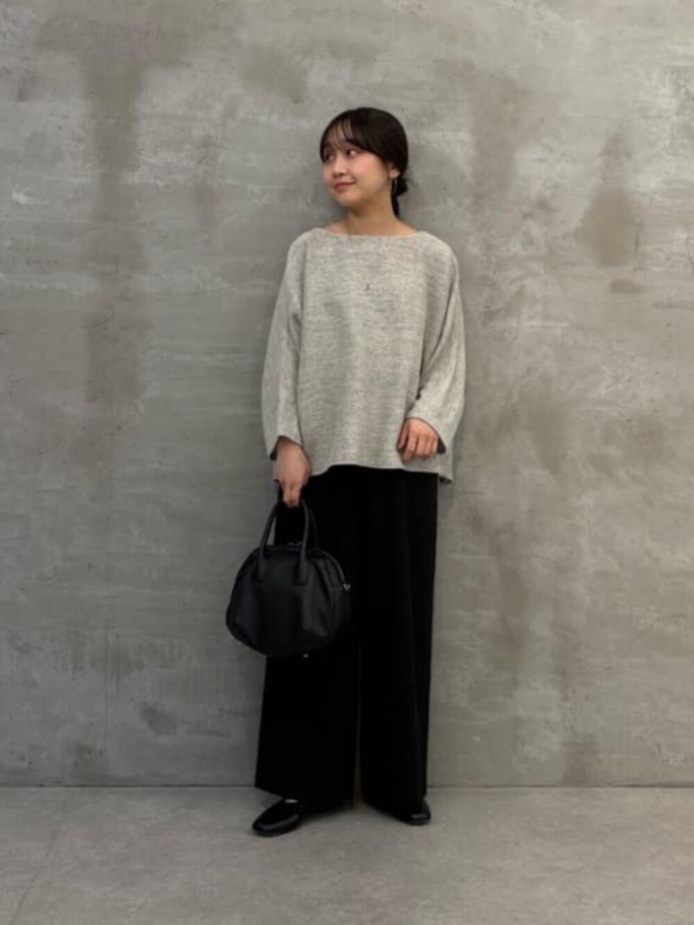グレー系のニット/セーター、ブラック系のその他パンツを着用したレディースの春コーディネートの2枚目の写真