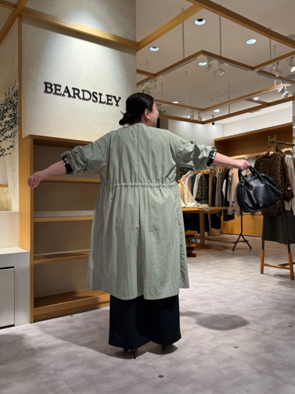 ブラック系のその他パンツ、ブラック系のシャツ/ブラウス、グリーン系のその他アウターを着用したレディースの冬コーディネートの4枚目の写真