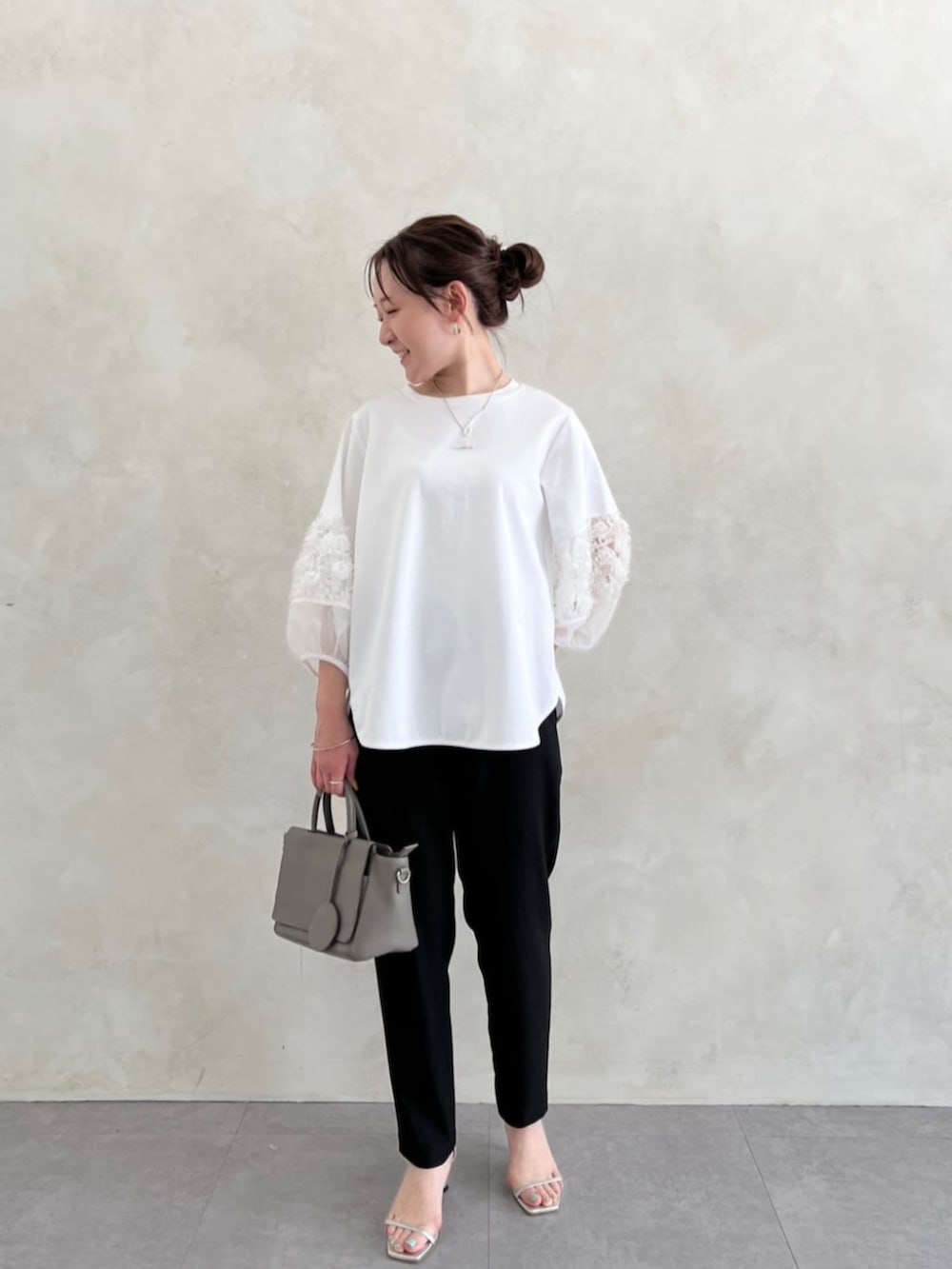グレー系のハンドバッグ、ブラック系のその他パンツ、ホワイト系のTシャツ/カットソーを着用したレディースの春コーディネートの3枚目の写真
