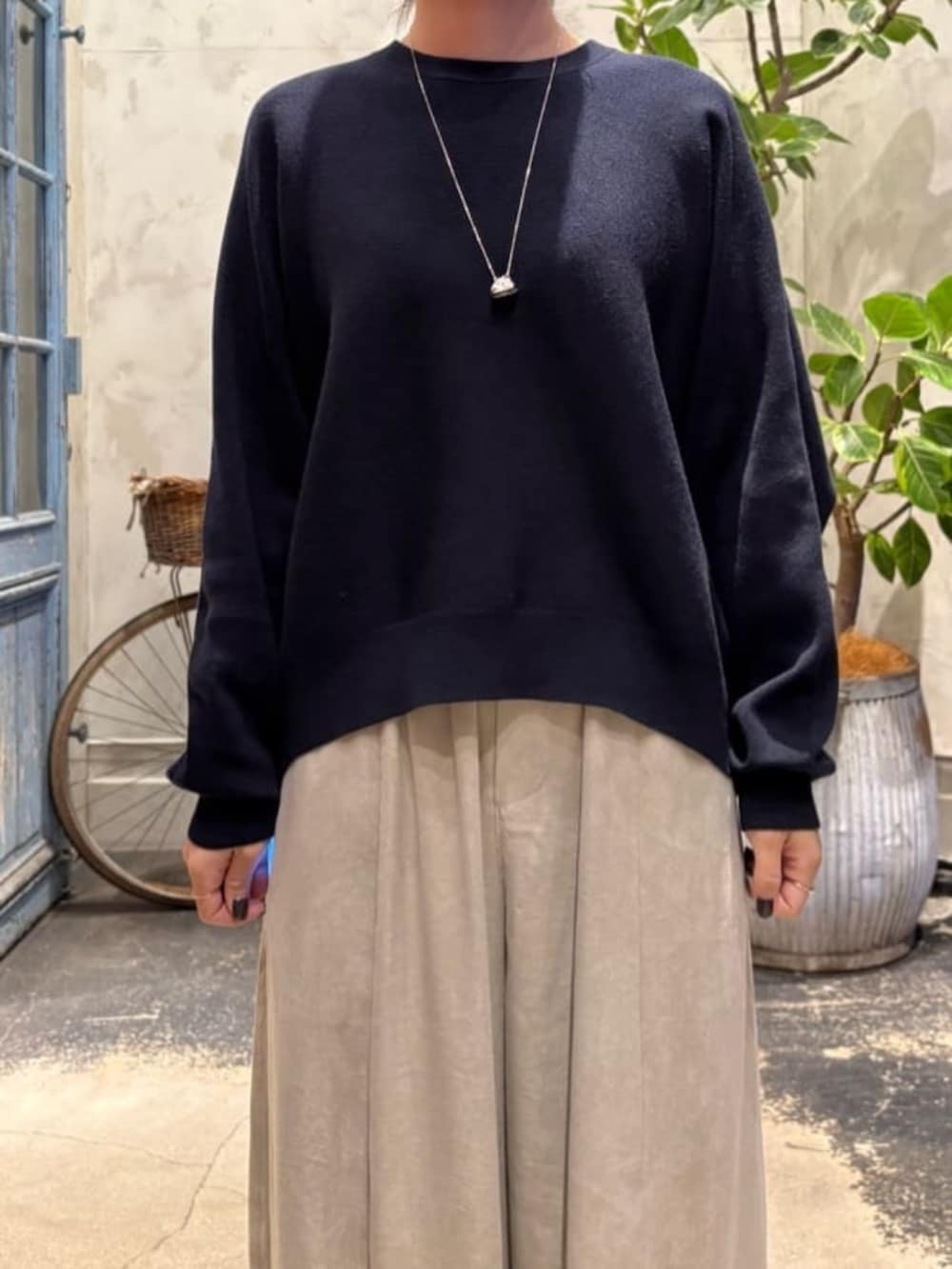 ブルー系のニット/セーター、グレー系のその他パンツを着用したレディースの夏コーディネートの8枚目の写真