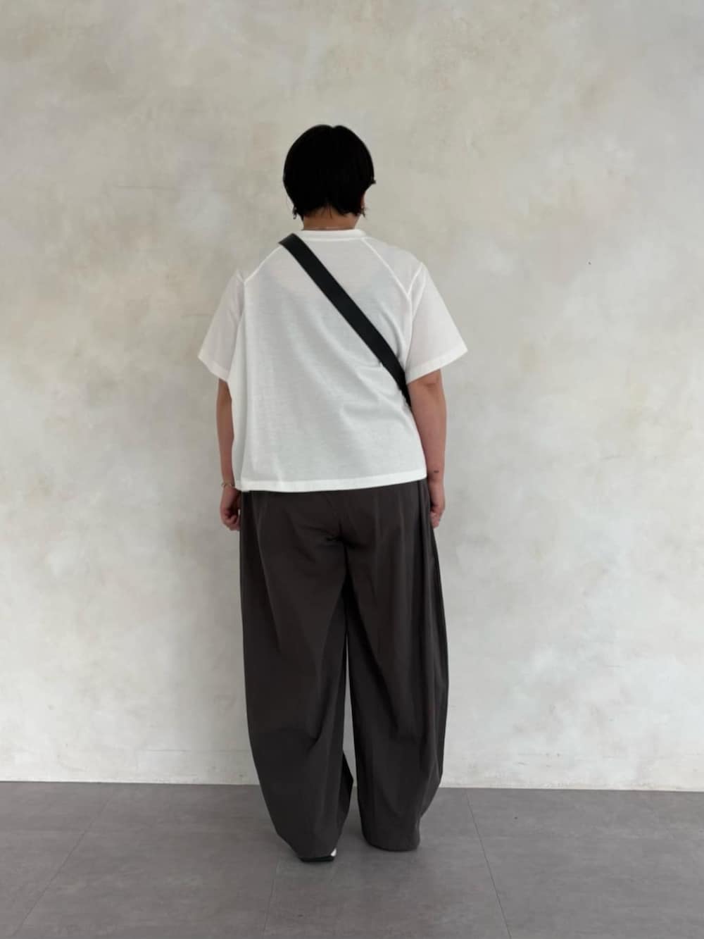 ブラック系のショルダーバッグ、グレー系のその他パンツ、ホワイト系のTシャツ/カットソーを着用したレディースの春コーディネートの4枚目の写真