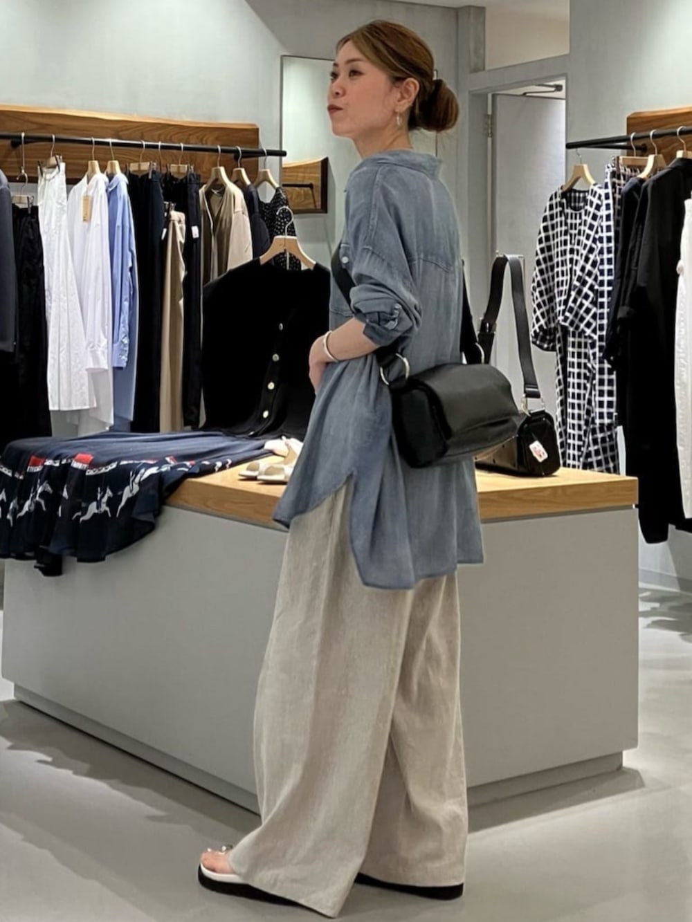 ブルー系のシャツ/ブラウス、ブラック系のショルダーバッグ、ベージュ系のその他パンツを着用したレディースの夏コーディネートの2枚目の写真