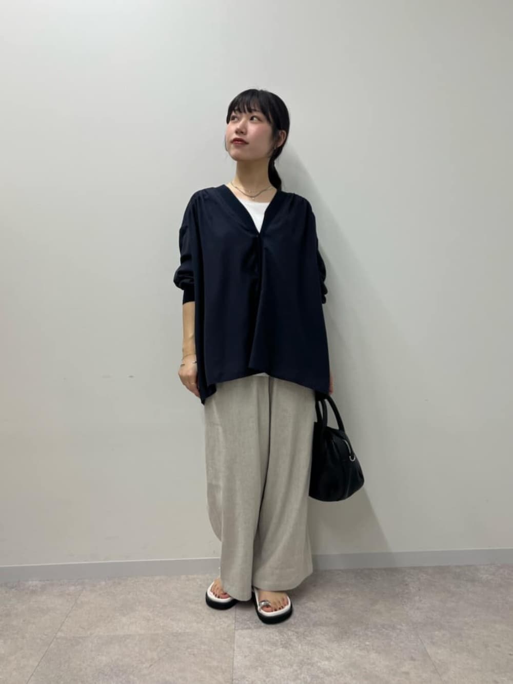 ブラック系のボストンバッグ、ホワイト系のサンダル、ブルー系のシャツ/ブラウスを着用したレディースの春コーディネートの3枚目の写真