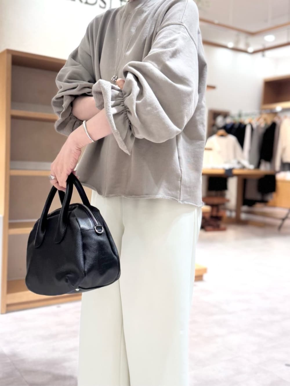 ブラック系のボストンバッグ、ブラウン系のTシャツ/カットソー、ホワイト系のその他パンツを着用したレディースの冬コーディネートの8枚目の写真