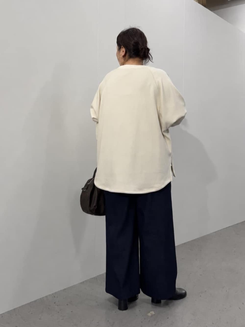 ブルー系のその他パンツ、ブラウン系のトートバッグ、ホワイト系のTシャツ/カットソーを着用したレディースの秋コーディネートの9枚目の写真