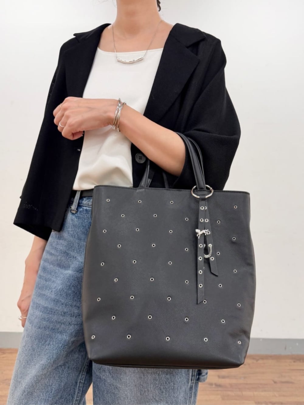 ブルー系のその他パンツ、ブラック系のテーラードジャケット、ブラック系のトートバッグを着用したレディースの夏コーディネートの5枚目の写真