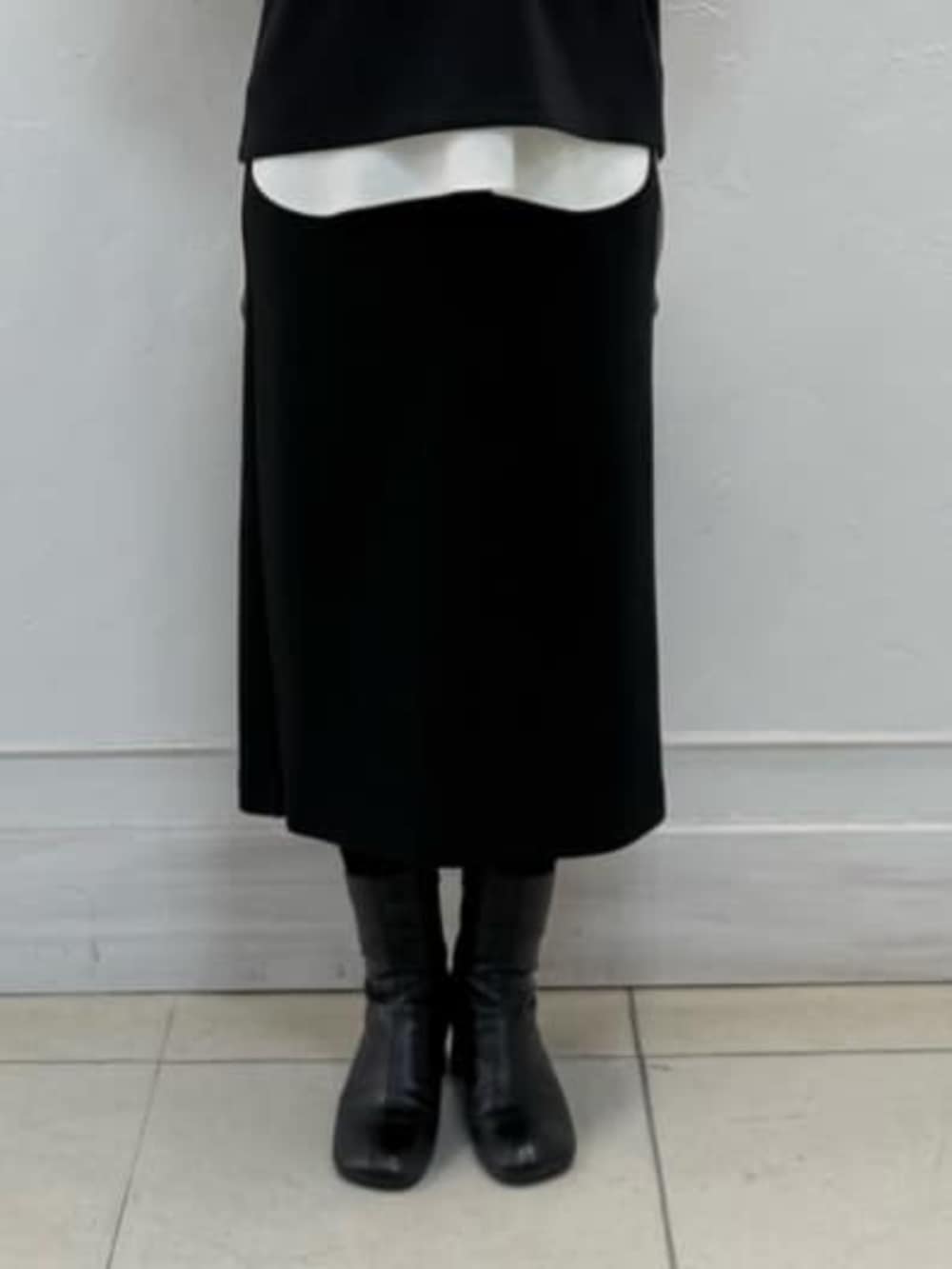 ホワイト系のシャツ/ブラウス、ブラック系のスカート、ブラック系のTシャツ/カットソーを着用したレディースの冬コーディネートの7枚目の写真