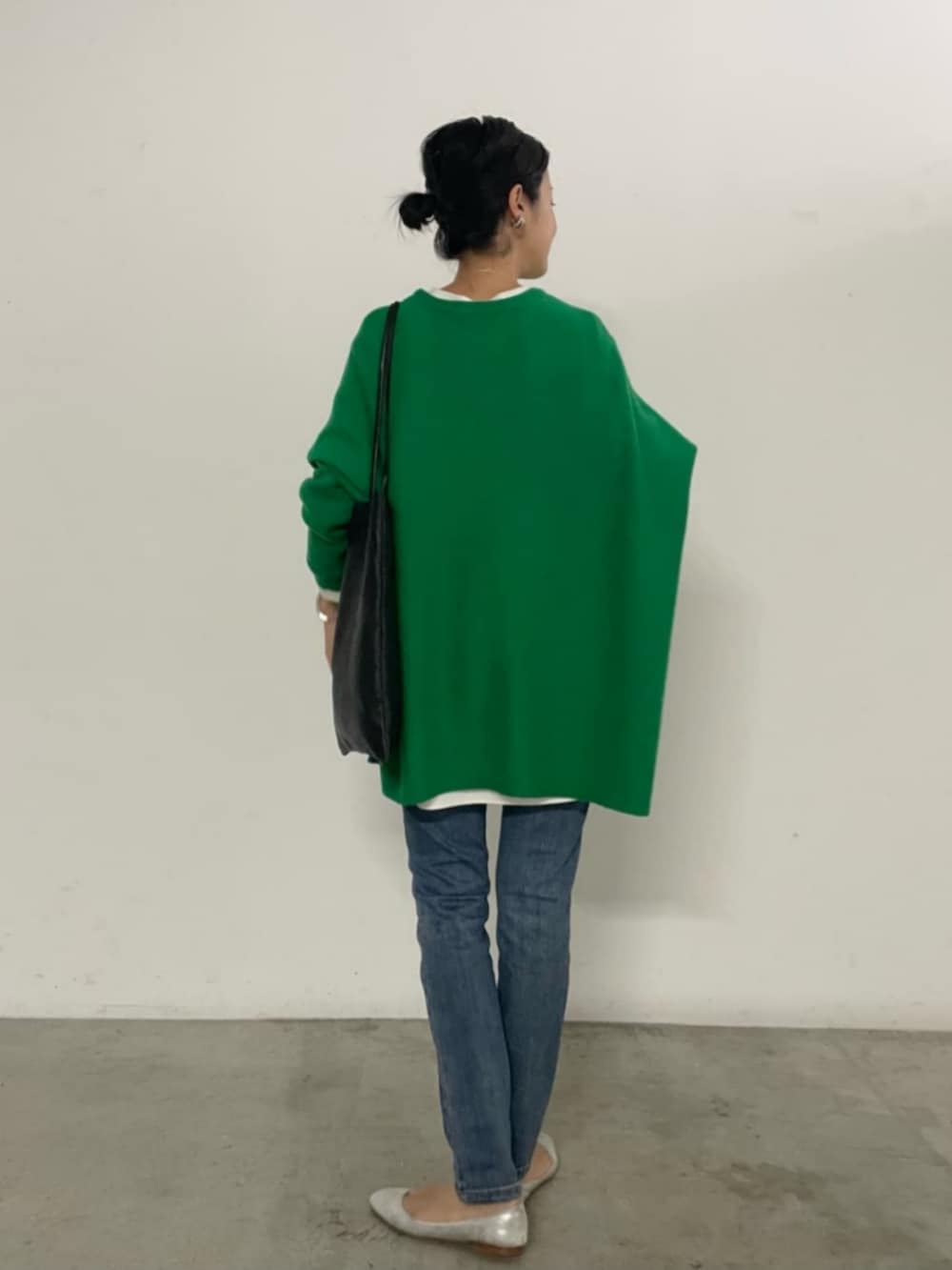 ブルー系のデニムパンツ、グリーン系のニット/セーターを着用したレディースの秋コーディネートの2枚目の写真