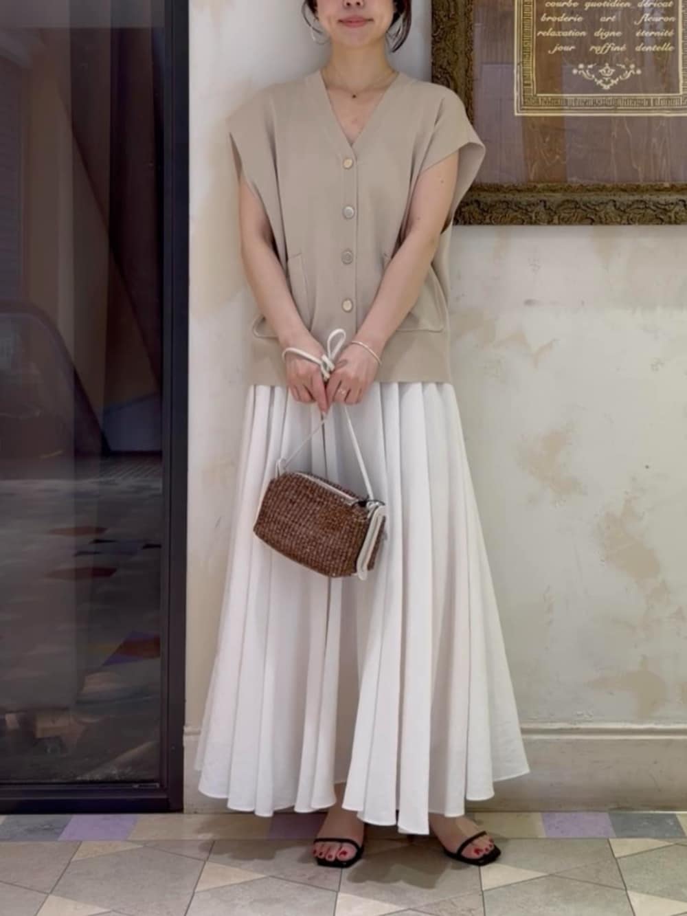 ホワイト系のスカート、ベージュ系のカーディガン/ボレロを着用したレディースの春コーディネートの3枚目の写真