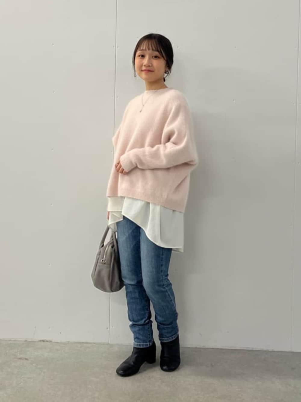 ブルー系のデニムパンツ、ピンク系のニット/セーターを着用したレディースの夏コーディネートの2枚目の写真