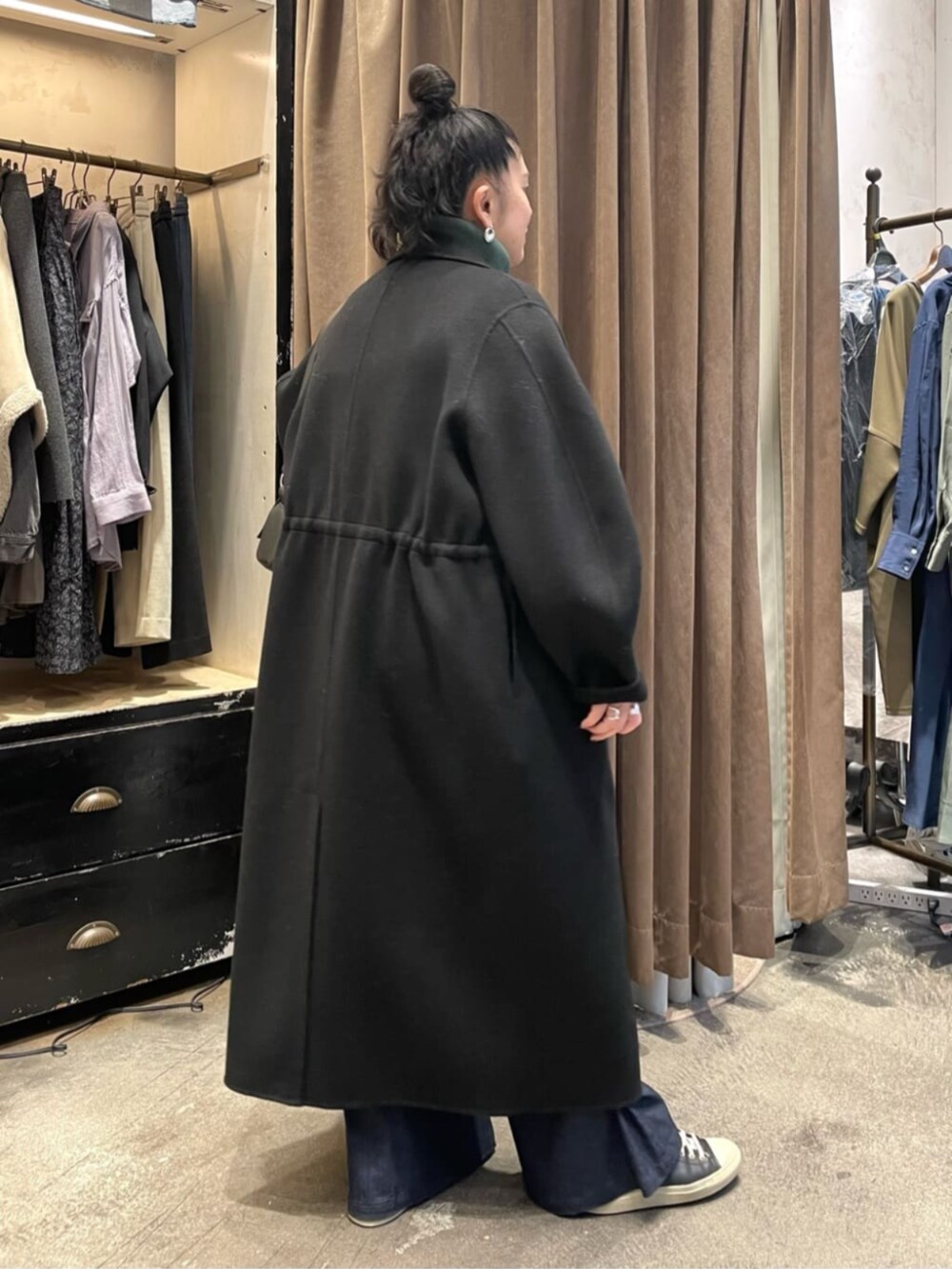 ブラック系のショルダーバッグ、ブラック系のその他アウター、グリーン系のニット/セーターを着用したレディースの冬コーディネートの4枚目の写真