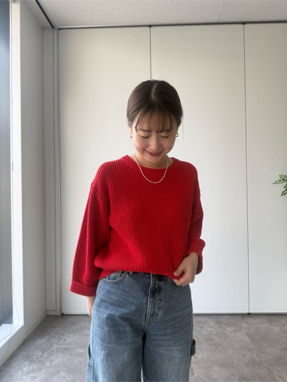 レッド系のニット/セーター、グレー系のトートバッグを着用したレディースの冬コーディネートの4枚目の写真