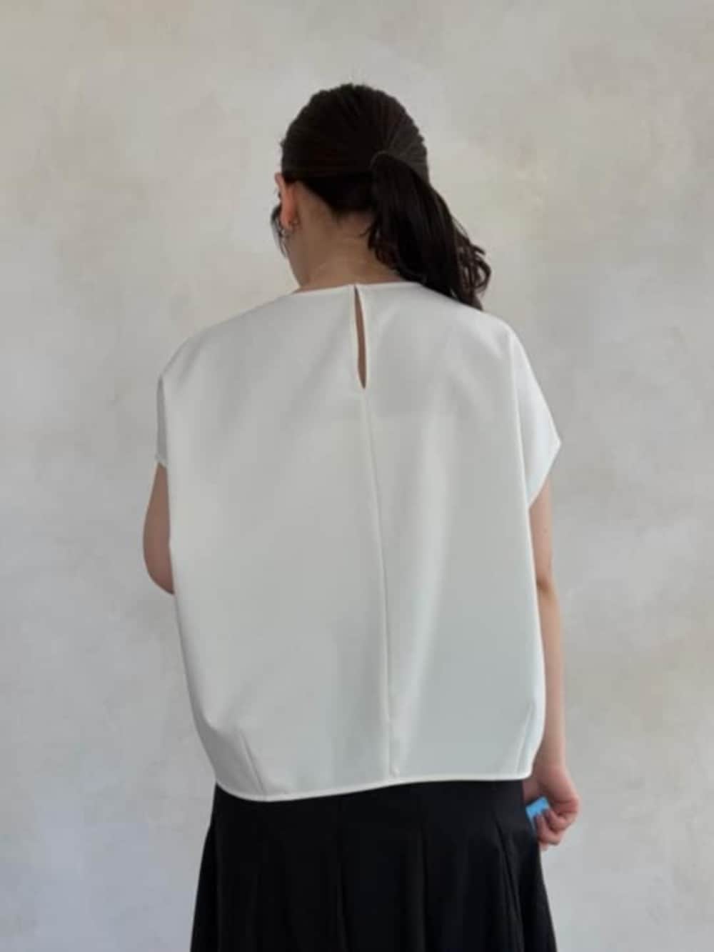 ブラック系のハンドバッグ、ホワイト系のシャツ/ブラウス、ブラック系のスカートを着用したレディースの春コーディネートの4枚目の写真