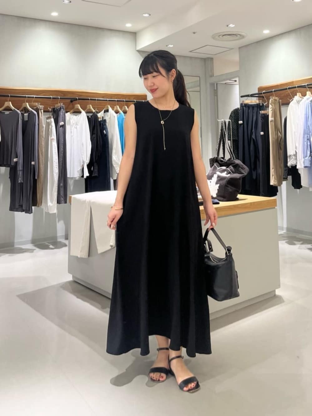 ブラック系のトートバッグ、ブラック系のワンピースを着用したレディースの夏コーディネートの2枚目の写真