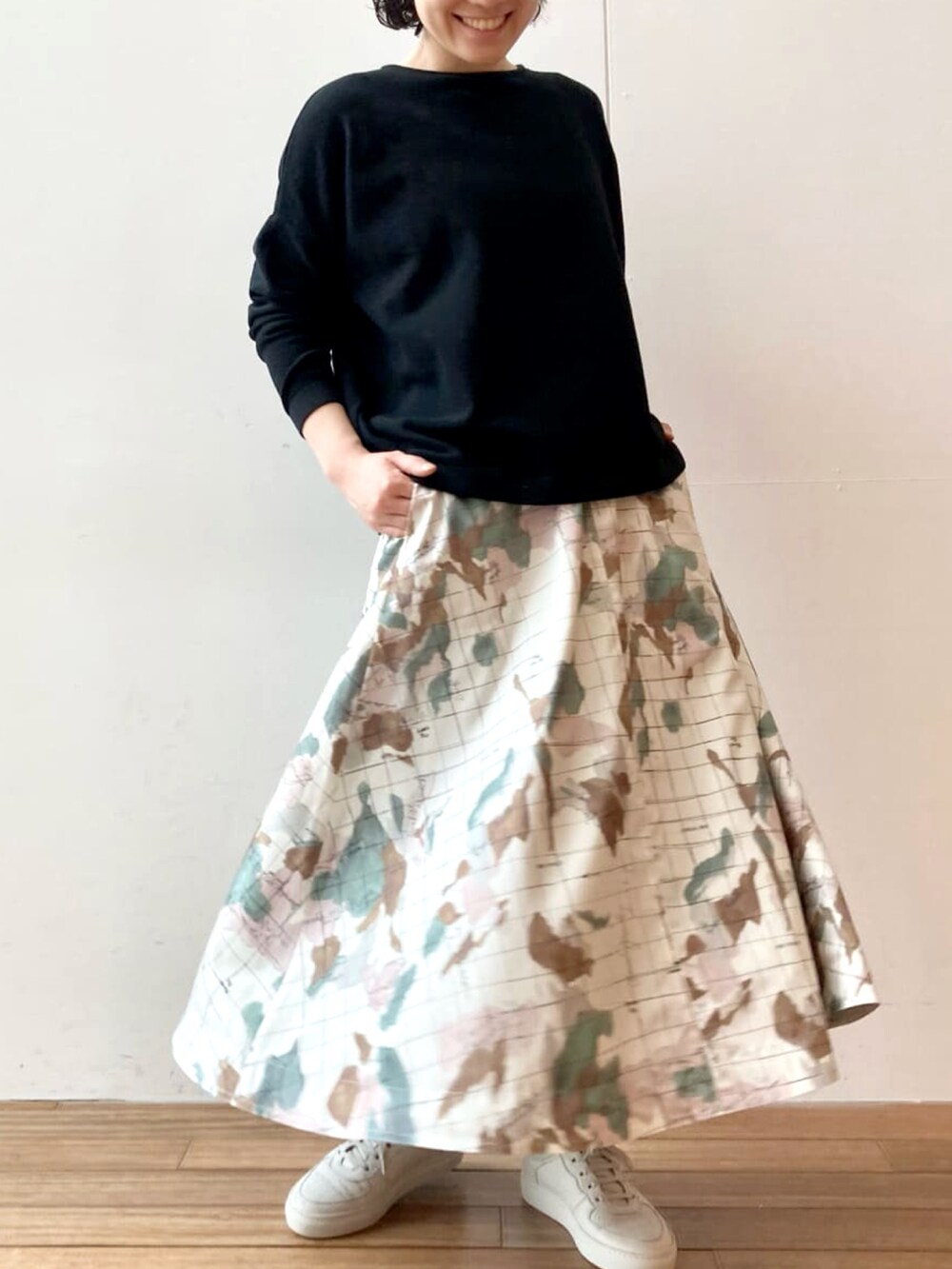 ブラック系のニット/セーター、ホワイト系のスカート、イエロー系のトートバッグを着用したレディースの春コーディネートの4枚目の写真