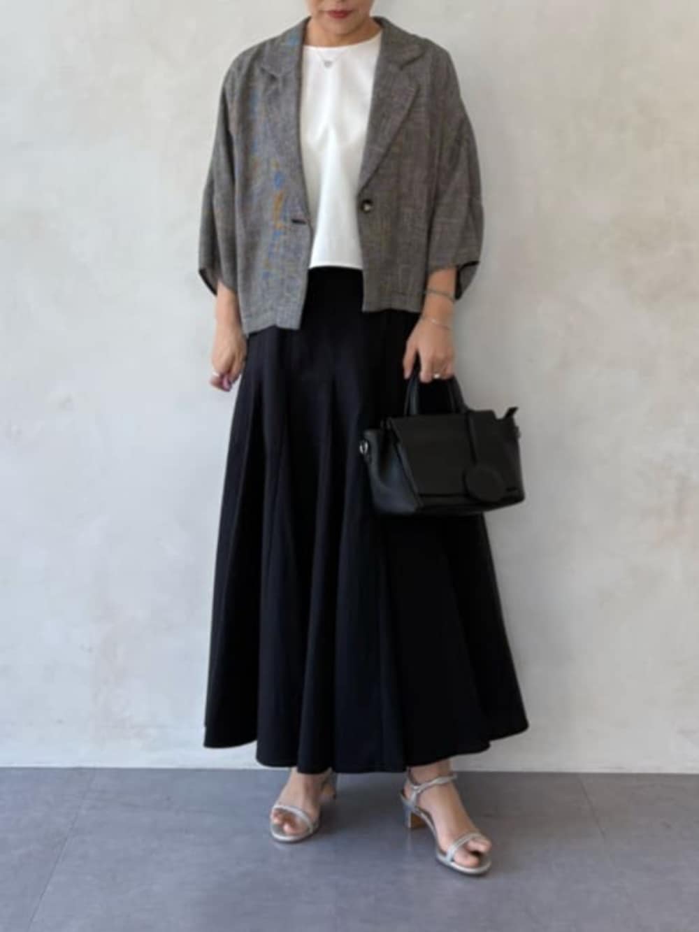 ベージュ系のテーラードジャケット、ホワイト系のシャツ/ブラウス、ブラック系のスカートを着用したレディースの春コーディネートの2枚目の写真