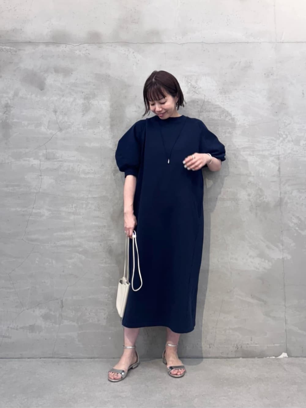 ホワイト系のショルダーバッグ、ブルー系のワンピースを着用したレディースの冬コーディネートの3枚目の写真