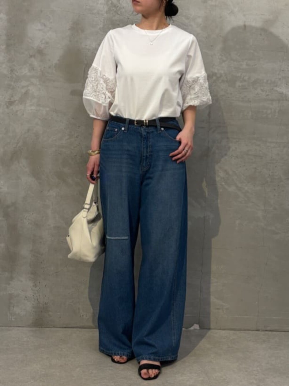 ホワイト系のトートバッグ、ブルー系のその他パンツ、ホワイト系のTシャツ/カットソーを着用したレディースの春コーディネートの2枚目の写真