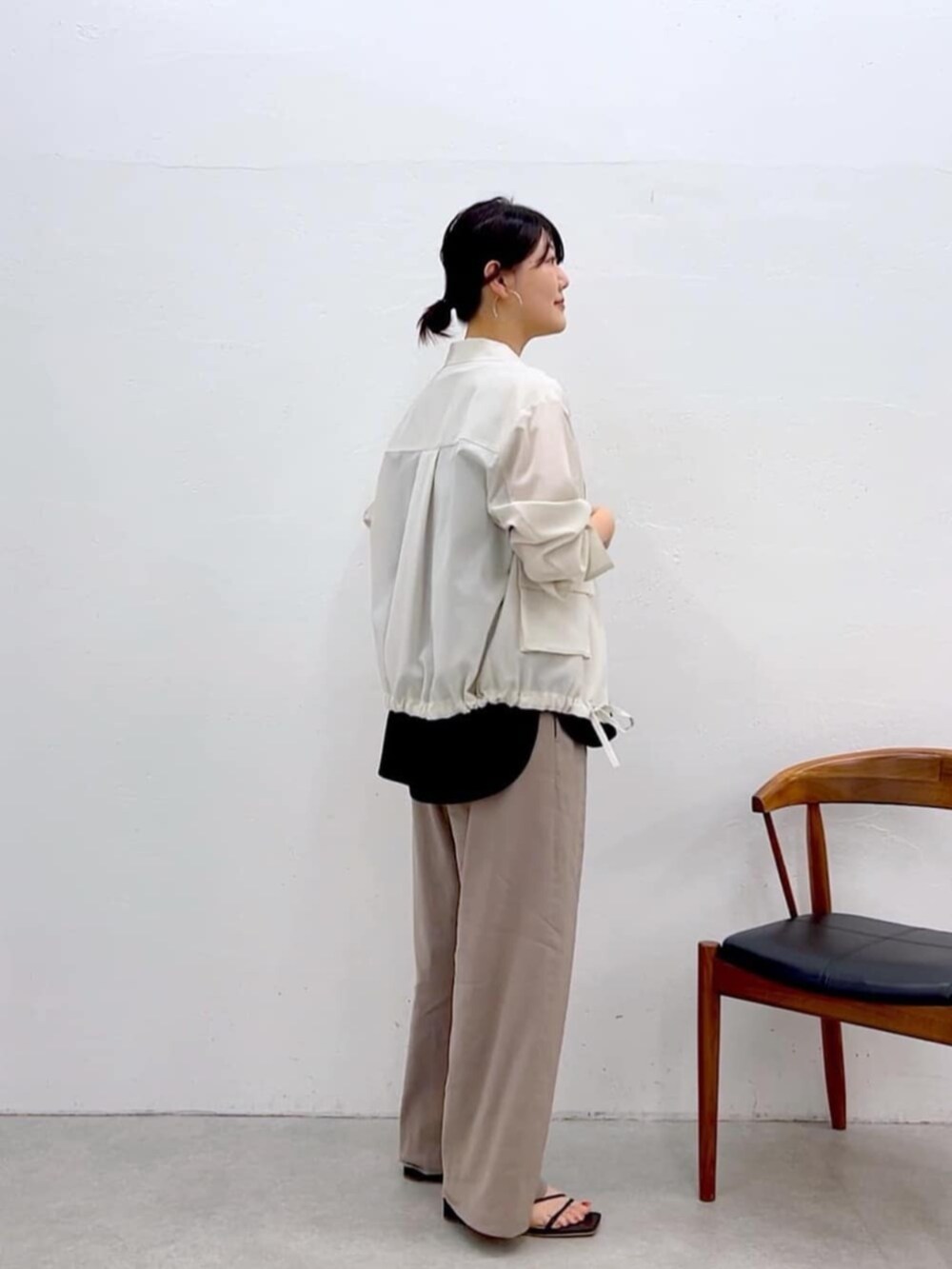 ブラック系のキャミソール、ホワイト系のブルゾン、グレー系のその他パンツを着用したレディースの夏コーディネートの6枚目の写真