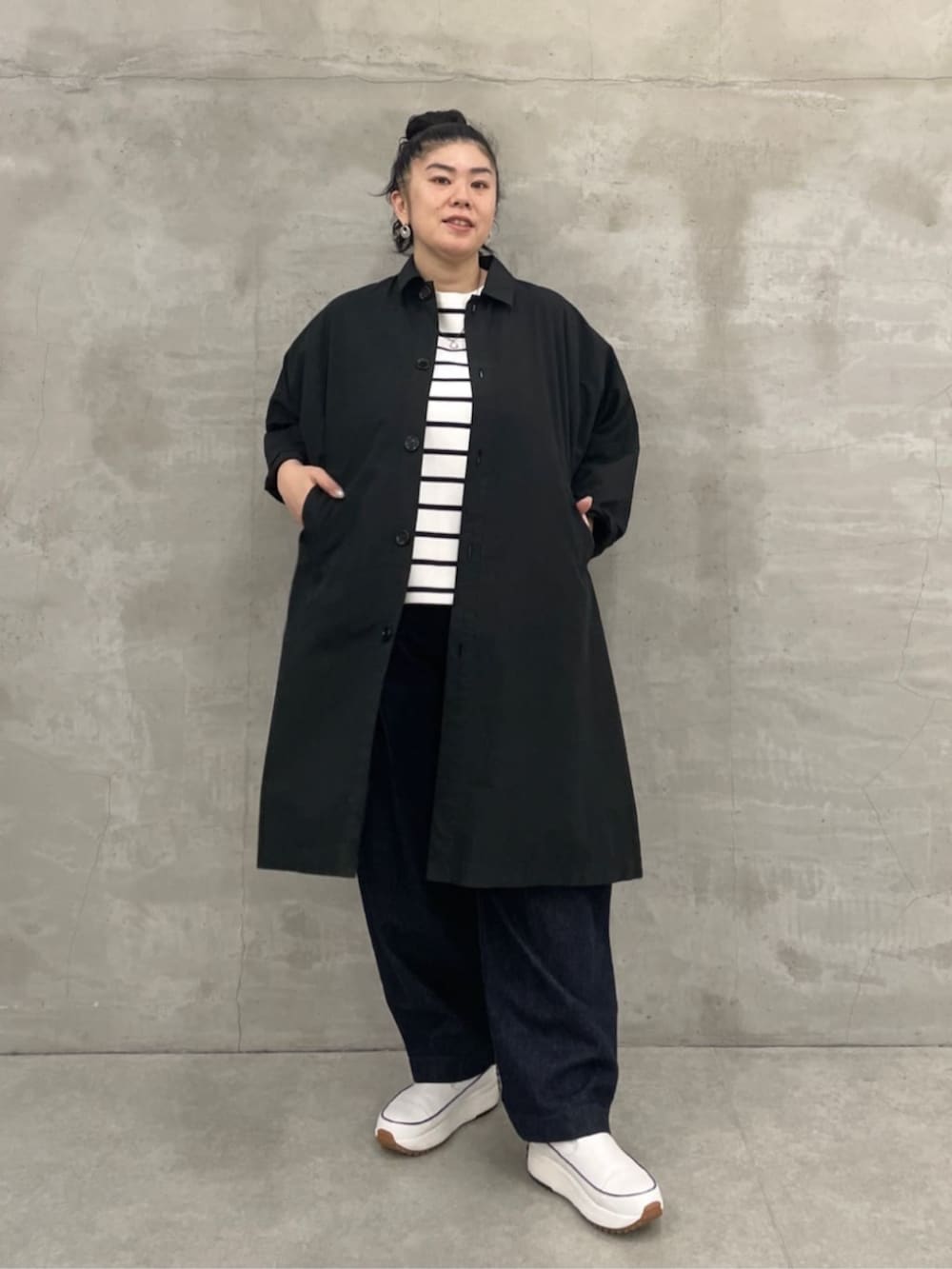 ホワイト系のトートバッグ、ブルー系のデニムパンツ、ブラック系のその他アウターを着用したレディースの冬コーディネートの4枚目の写真