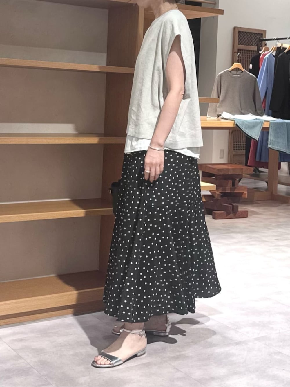 ブラック系のハンドバッグ、ブラック系のスカート、ベージュ系のシャツ/ブラウスを着用したレディースの春コーディネートの8枚目の写真