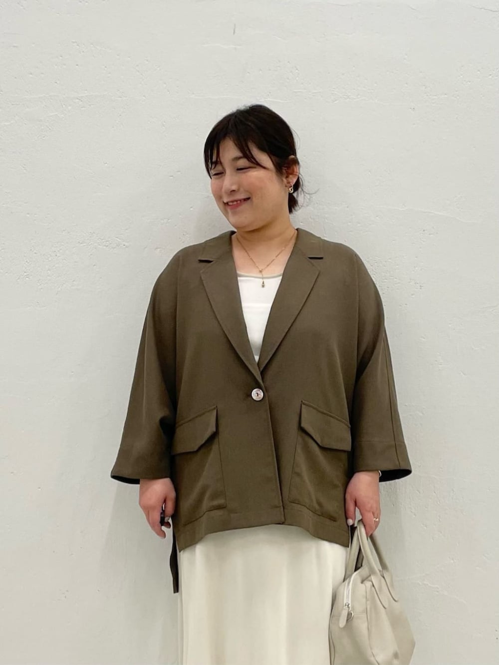 グレー系のボストンバッグ、ブラウン系のテーラードジャケットを着用したレディースの春コーディネートの4枚目の写真