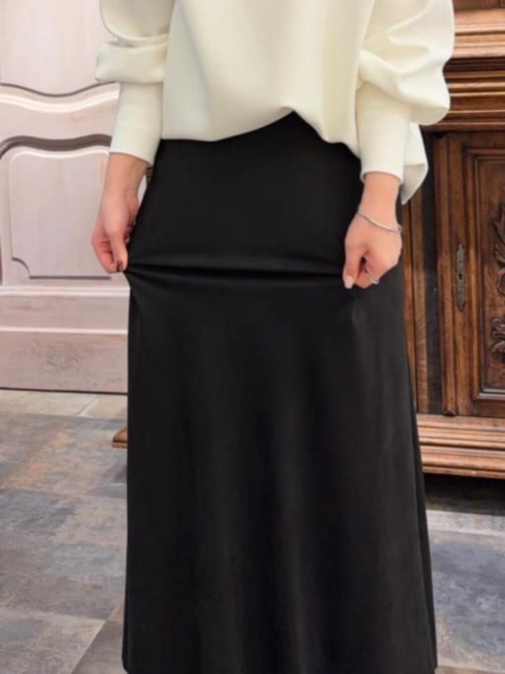 ブラック系のスカート、ブラック系のショルダーバッグ、ホワイト系のTシャツ/カットソーを着用したレディースの冬コーディネートの6枚目の写真