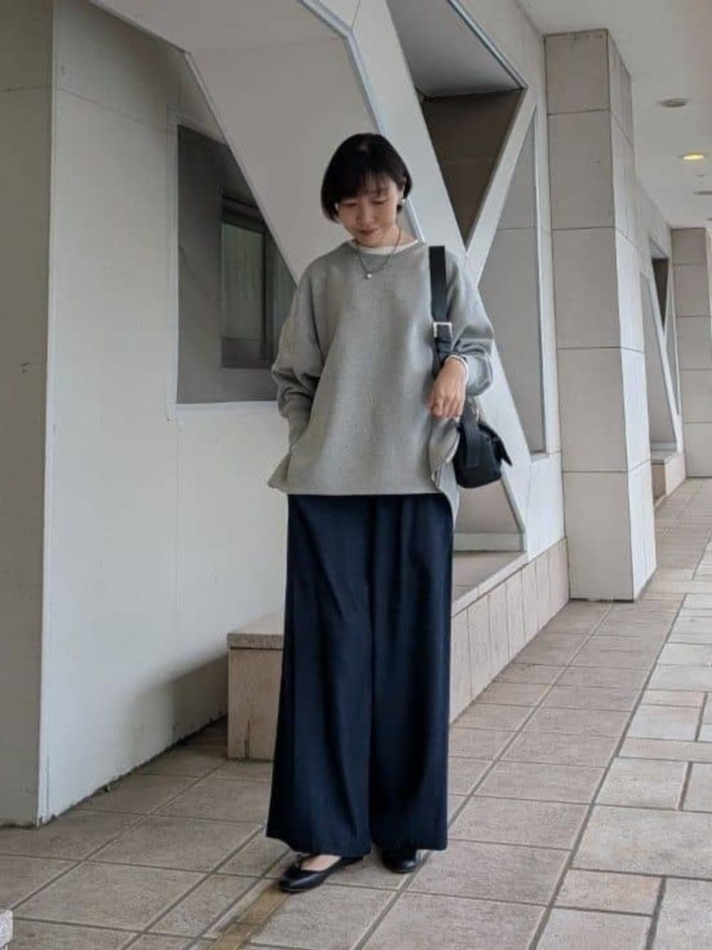 ブルー系のその他パンツ、グレー系のニット/セーター、ホワイト系のノーカラージャケットを着用したレディースの冬コーディネートの5枚目の写真