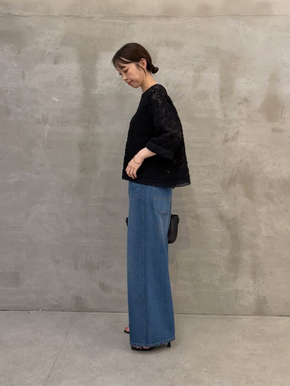 ブラック系のハンドバッグ、ブルー系のその他パンツ、ブラック系のシャツ/ブラウスを着用したレディースの春コーディネートの2枚目の写真