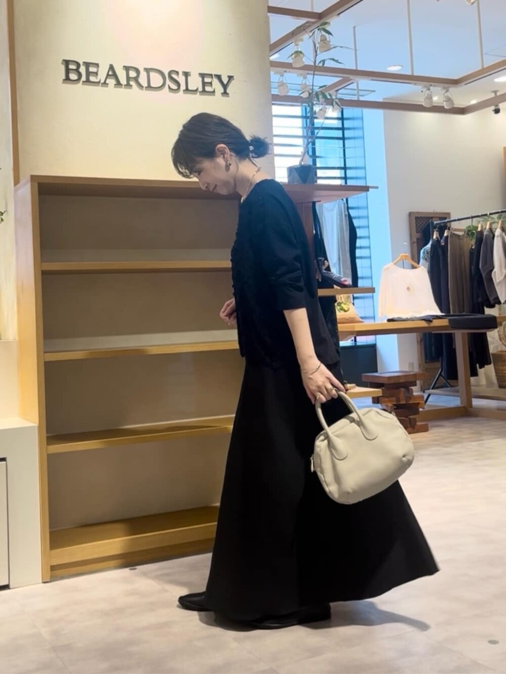 ブラック系のTシャツ/カットソー、ブラック系のスカートを着用したレディースの夏コーディネートの2枚目の写真