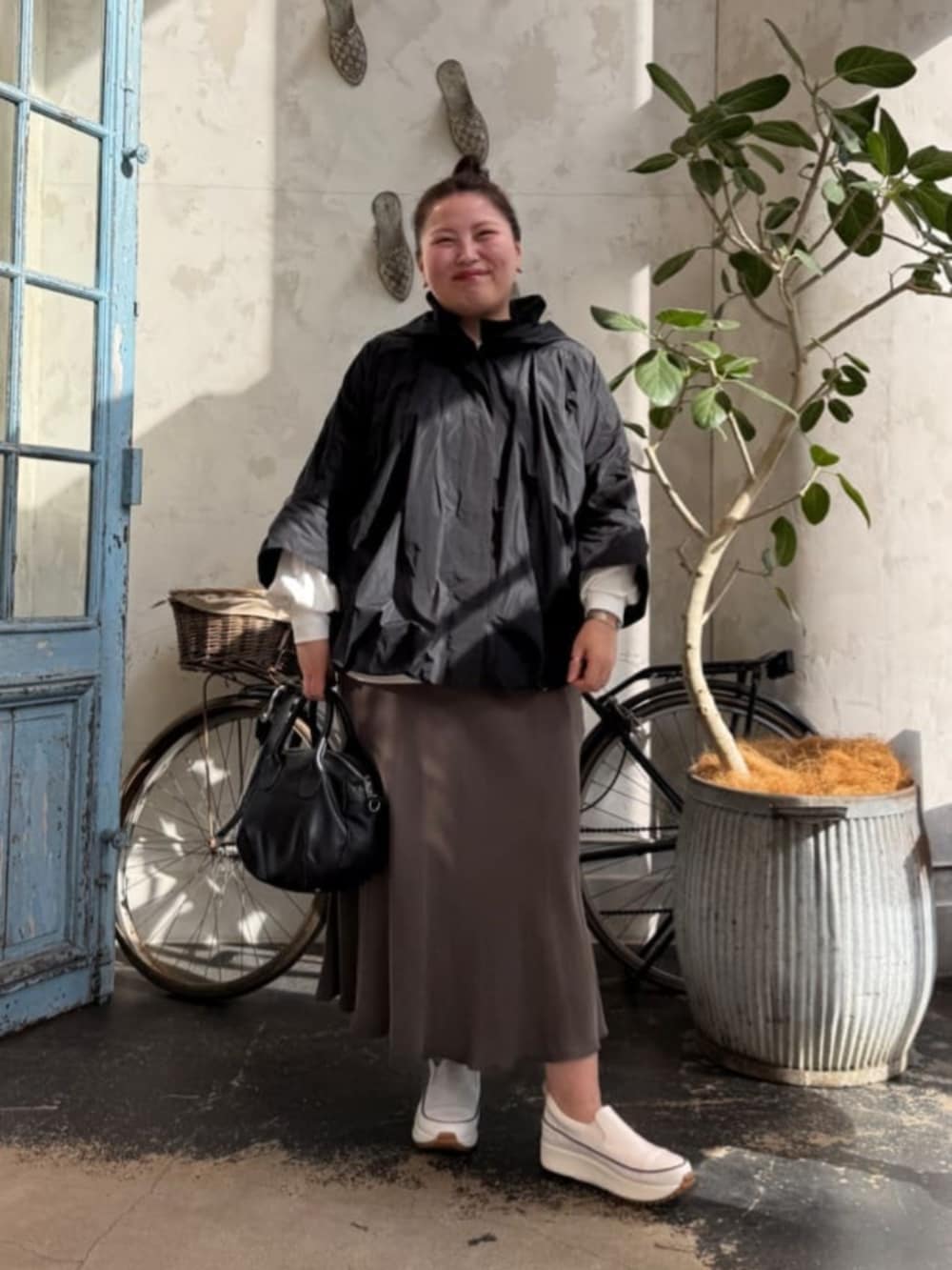 グリーン系のスカート、ブラック系のボストンバッグ、ホワイト系のシャツ/ブラウスを着用したレディースの冬コーディネートの4枚目の写真