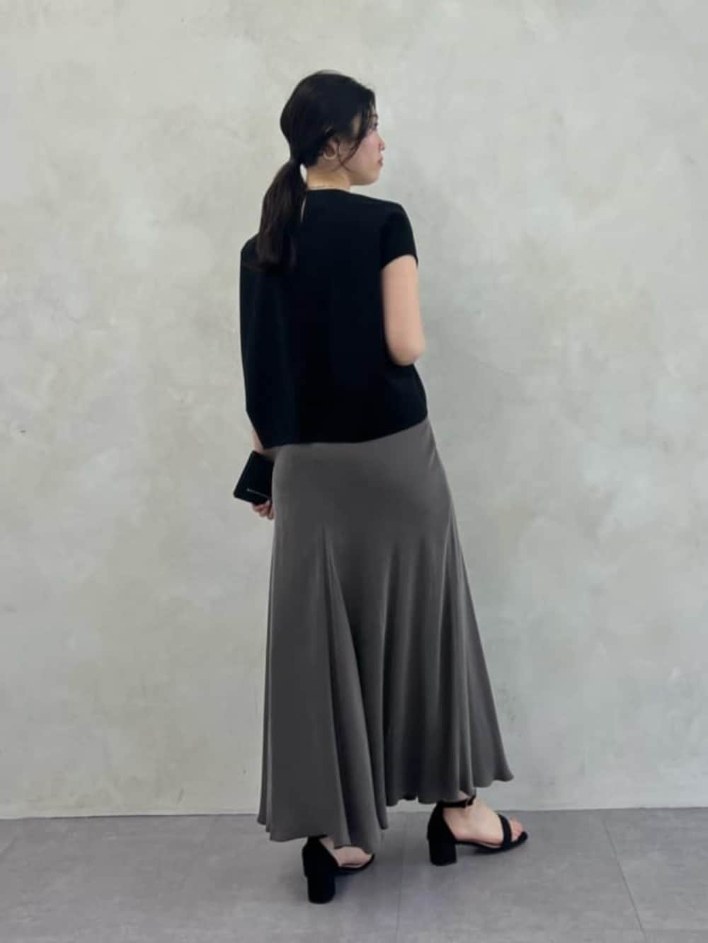 グリーン系のスカート、ブラック系のシャツ/ブラウスを着用したレディースの春コーディネートの2枚目の写真