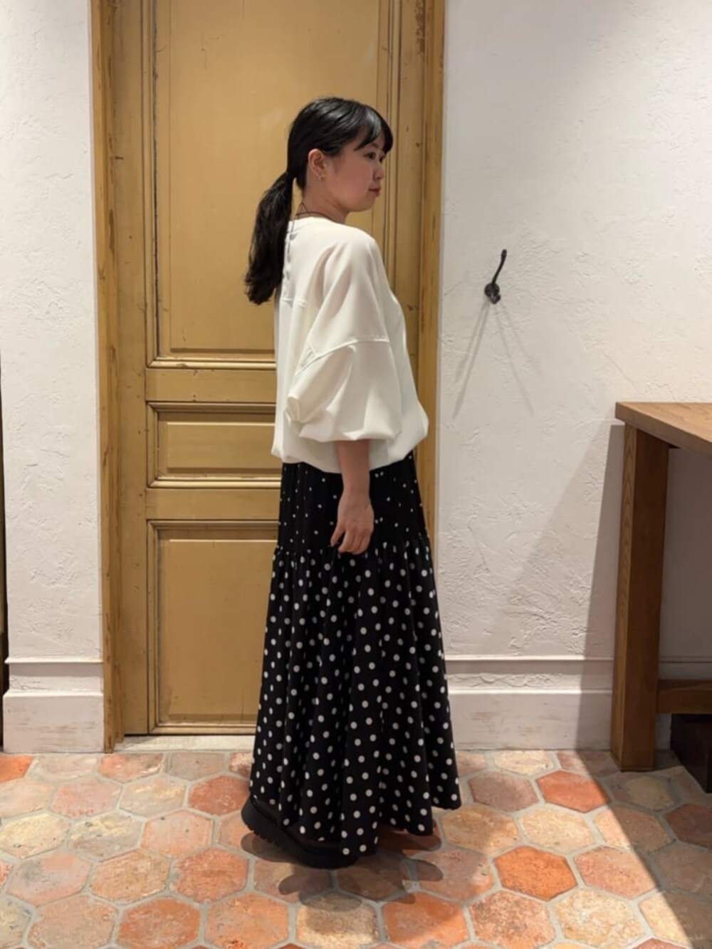 ブラック系のスカート、ピンク系のハンドバッグ、ホワイト系のシャツ/ブラウスを着用したレディースの冬コーディネートの3枚目の写真