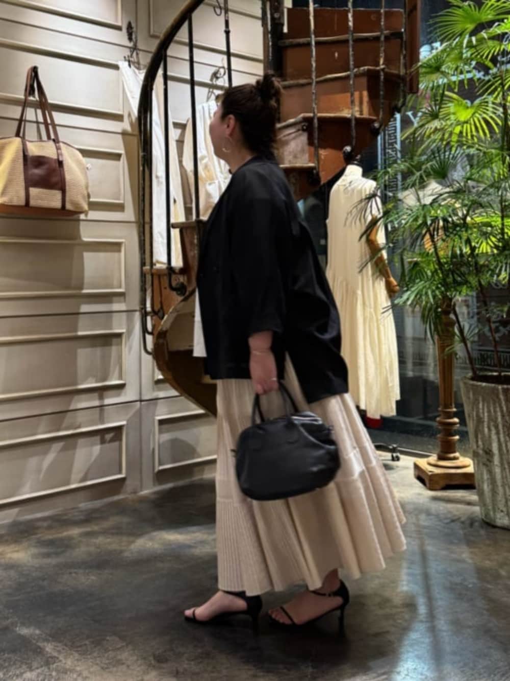 ホワイト系のスカート、ブラック系のテーラードジャケットを着用したレディースの春コーディネートの3枚目の写真