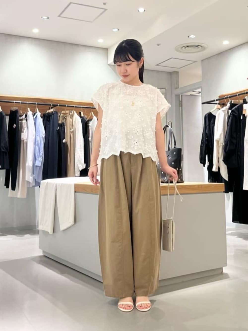 ホワイト系のショルダーバッグ、イエロー系のその他パンツ、ホワイト系のシャツ/ブラウスを着用したレディースの夏コーディネートの3枚目の写真