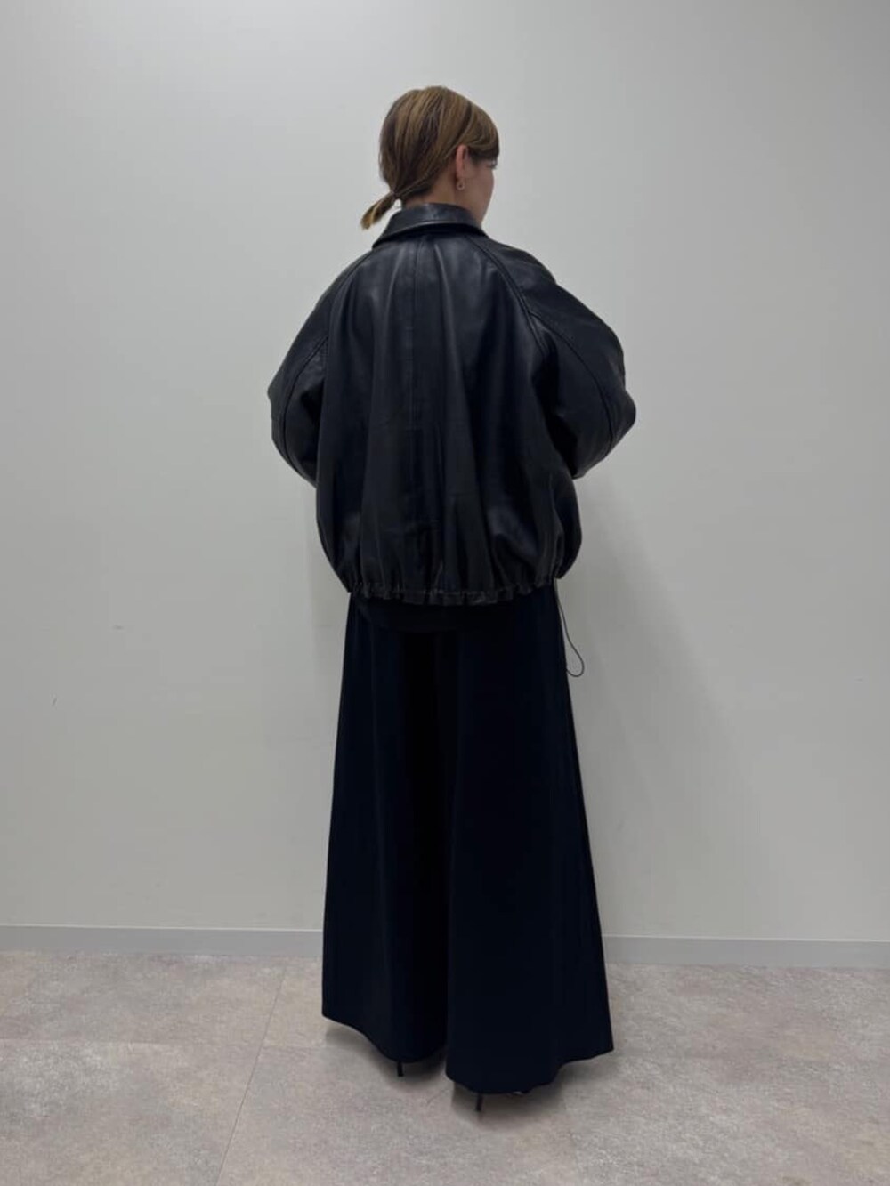 ブラック系のブルゾン、ブラック系のその他パンツを着用したレディースの冬コーディネートの2枚目の写真