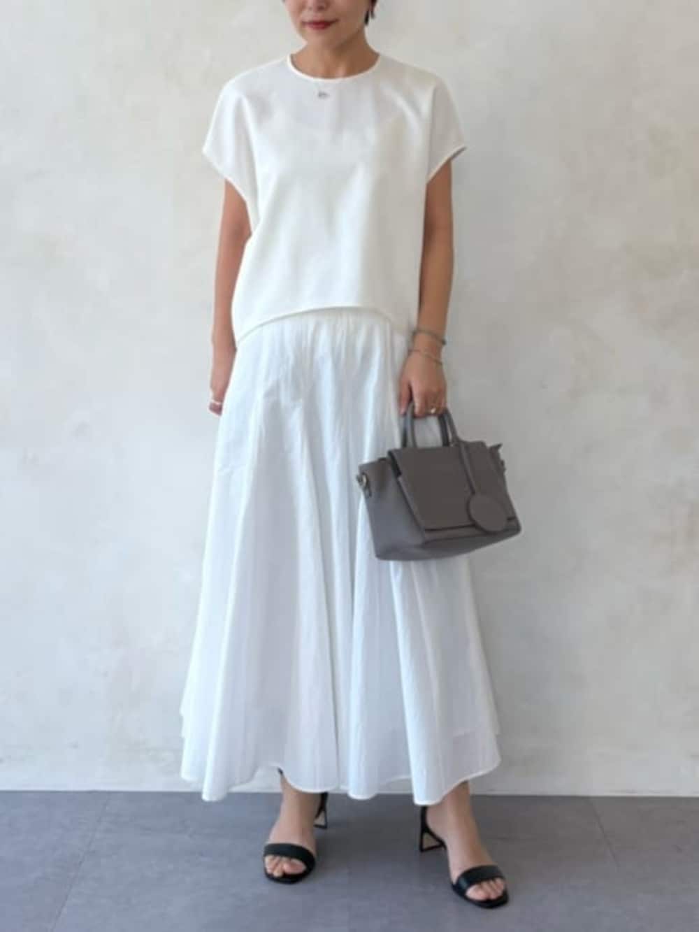 グレー系のハンドバッグ、ホワイト系のスカート、ホワイト系のシャツ/ブラウスを着用したレディースの春コーディネートの4枚目の写真