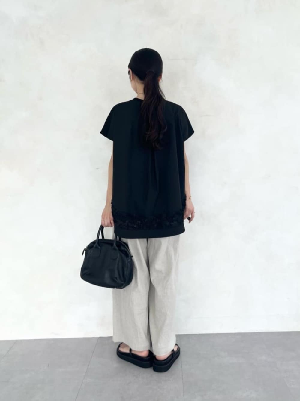 ベージュ系のその他パンツ、ブラック系のTシャツ/カットソー、ブラック系のサンダルを着用したレディースの春コーディネートの6枚目の写真