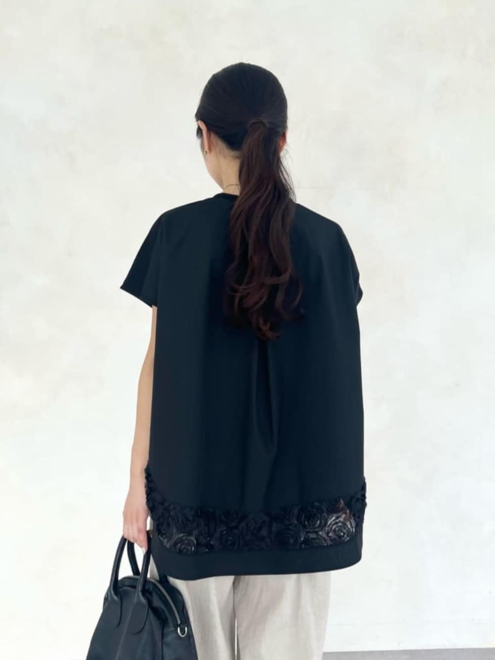 ベージュ系のその他パンツ、ブラック系のTシャツ/カットソー、ブラック系のサンダルを着用したレディースの春コーディネートの9枚目の写真