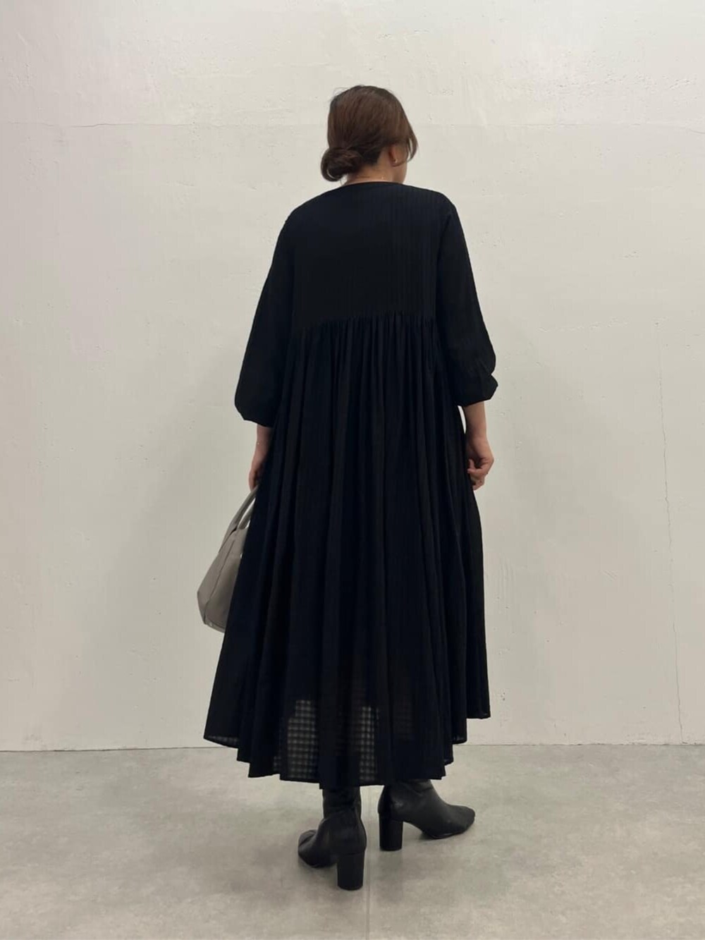 グレー系のボストンバッグ、ブラック系のワンピースを着用したレディースの夏コーディネートの5枚目の写真