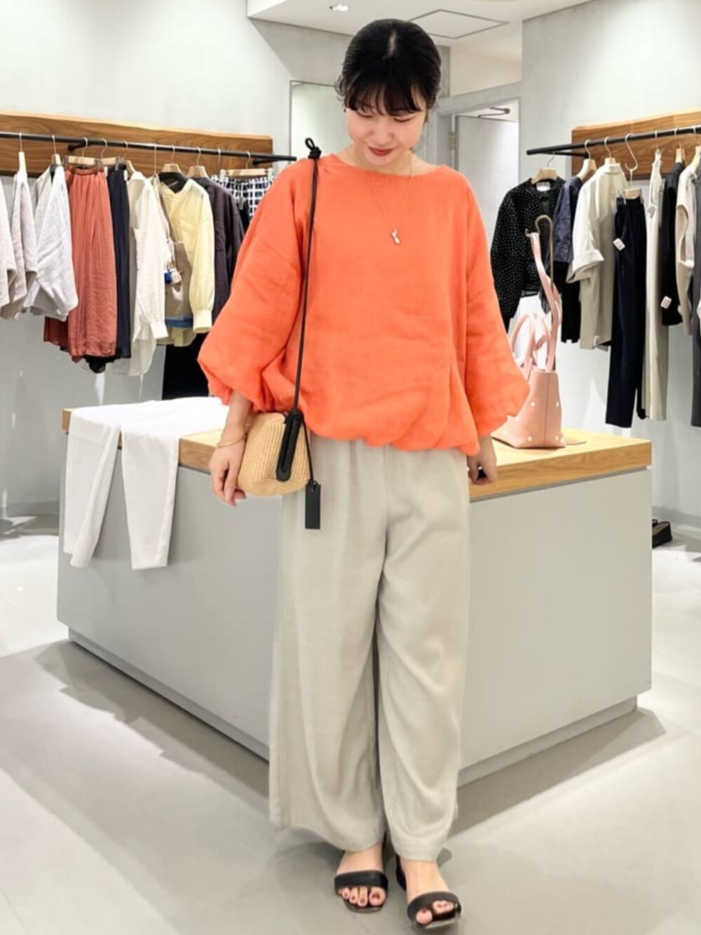 グレー系のその他パンツ、オレンジ系のシャツ/ブラウスを着用したレディースの春コーディネートの8枚目の写真
