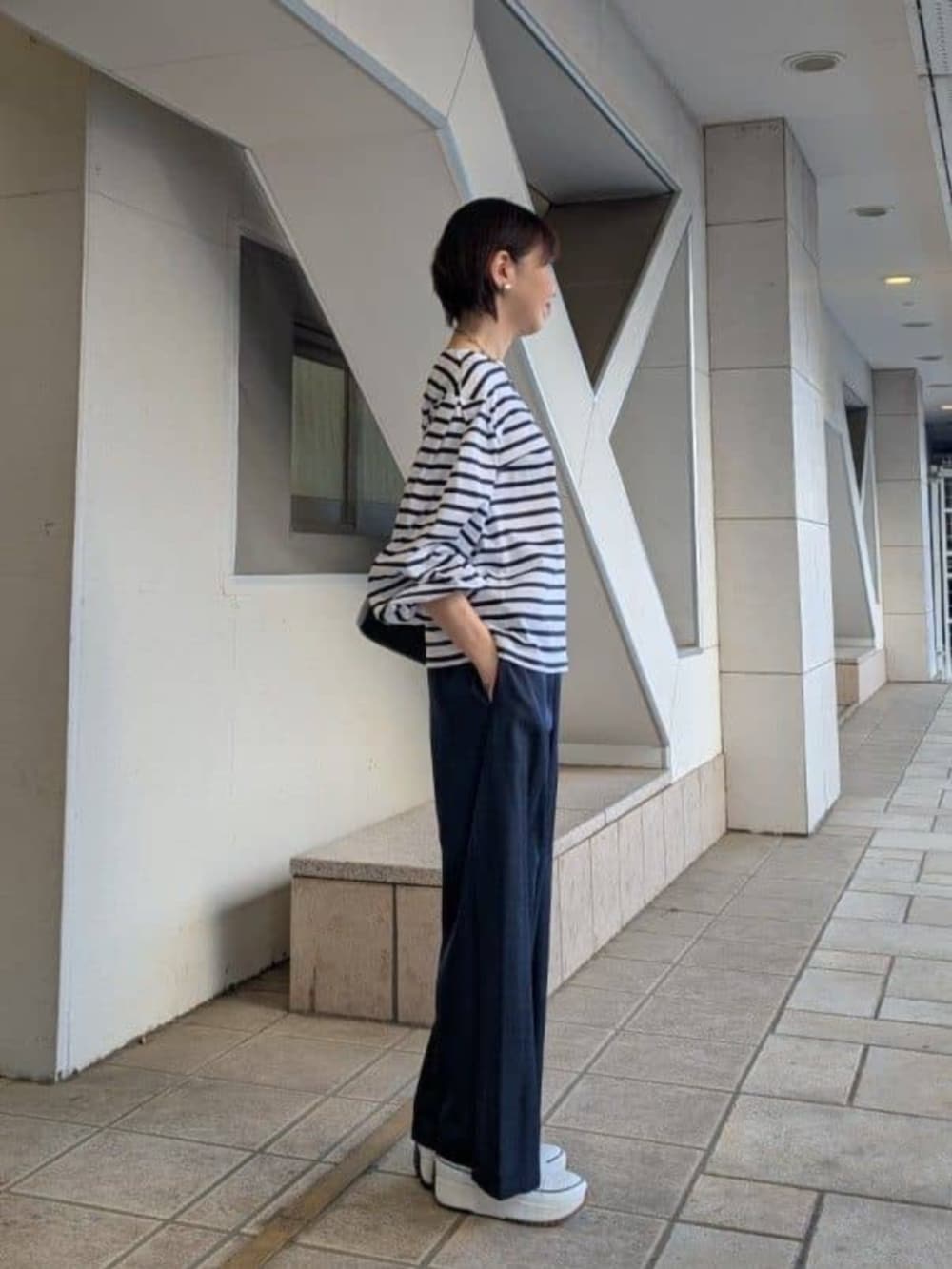 ブルー系のその他パンツ、ホワイト系のTシャツ/カットソー、ホワイト系のスニーカーを着用したレディースの春コーディネートの2枚目の写真