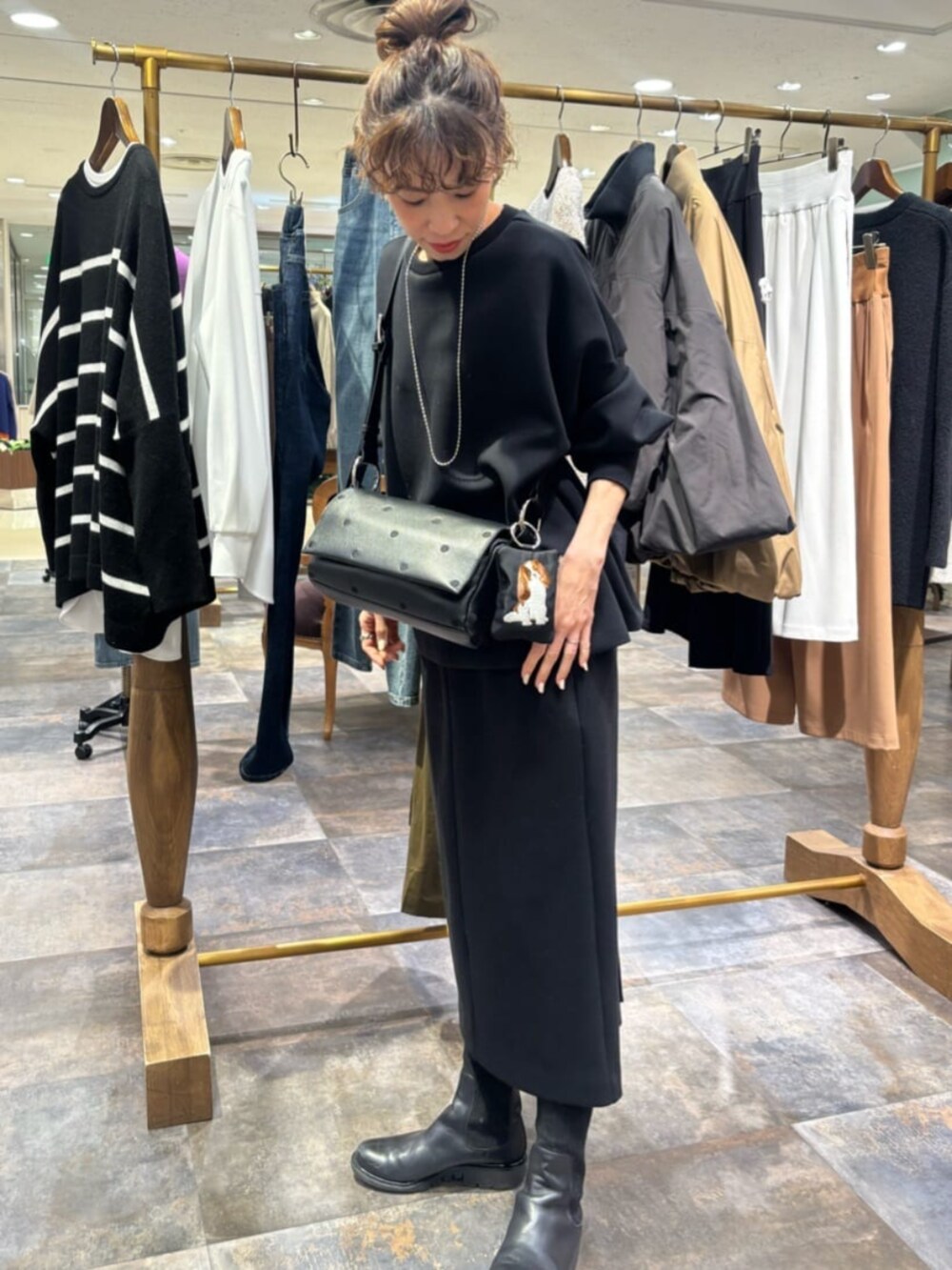 ブラック系のポーチを着用したレディースの冬コーディネートの3枚目の写真