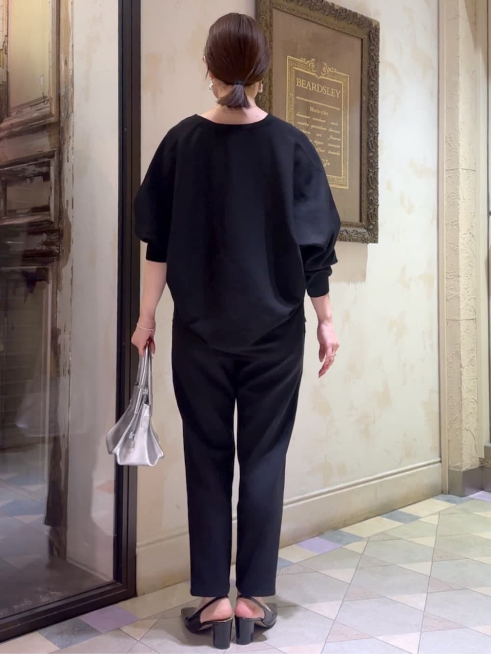 ブラック系のカーディガン/ボレロ、ブラック系のその他パンツ、シルバー系のトートバッグを着用したレディースの冬コーディネートの3枚目の写真