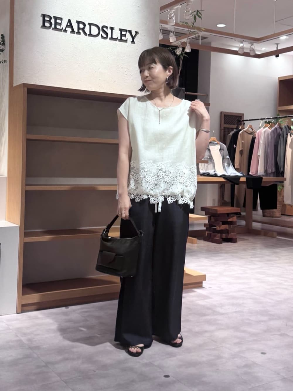 ブルー系のその他パンツ、ブラック系のトートバッグ、ホワイト系のシャツ/ブラウスを着用したレディースの春コーディネートの4枚目の写真