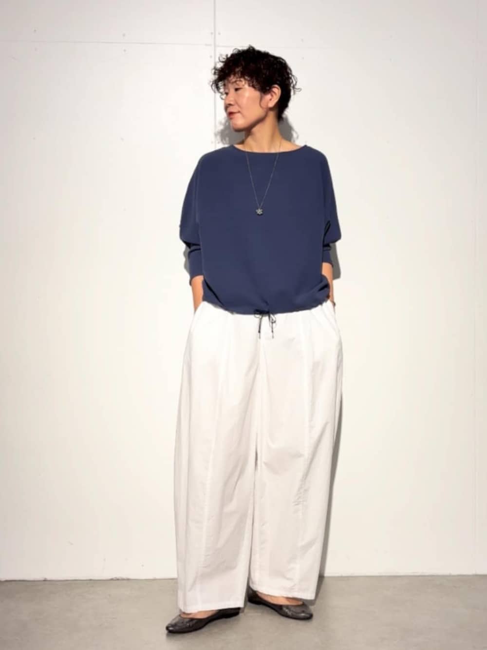 ブラック系のハンドバッグ、ブルー系のシャツ/ブラウス、ホワイト系のその他パンツを着用したレディースの春コーディネートの2枚目の写真