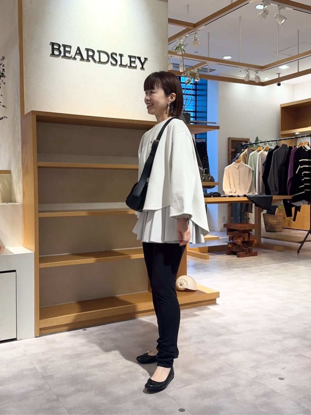 ブラック系のその他パンツ、ブラック系のショルダーバッグ、ホワイト系のTシャツ/カットソーを着用したレディースの冬コーディネートの4枚目の写真