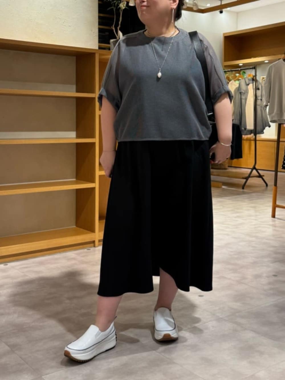 ホワイト系のスニーカー、ブラック系のワンピース、グレー系のTシャツ/カットソーを着用したレディースの夏コーディネートの7枚目の写真