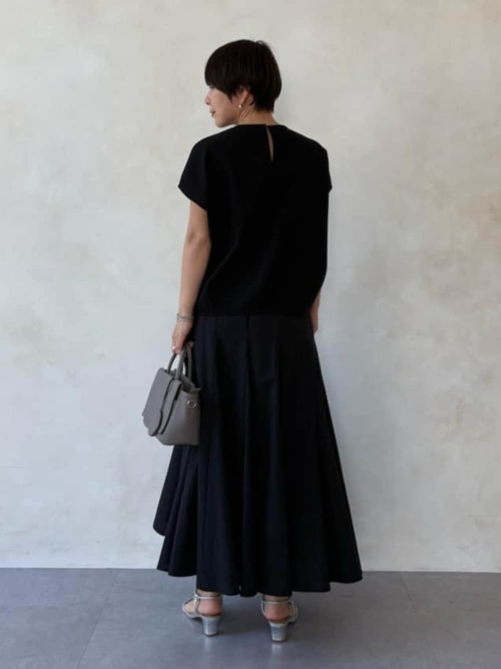 グレー系のハンドバッグ、ブラック系のシャツ/ブラウス、ブラック系のスカートを着用したレディースの春コーディネートの5枚目の写真