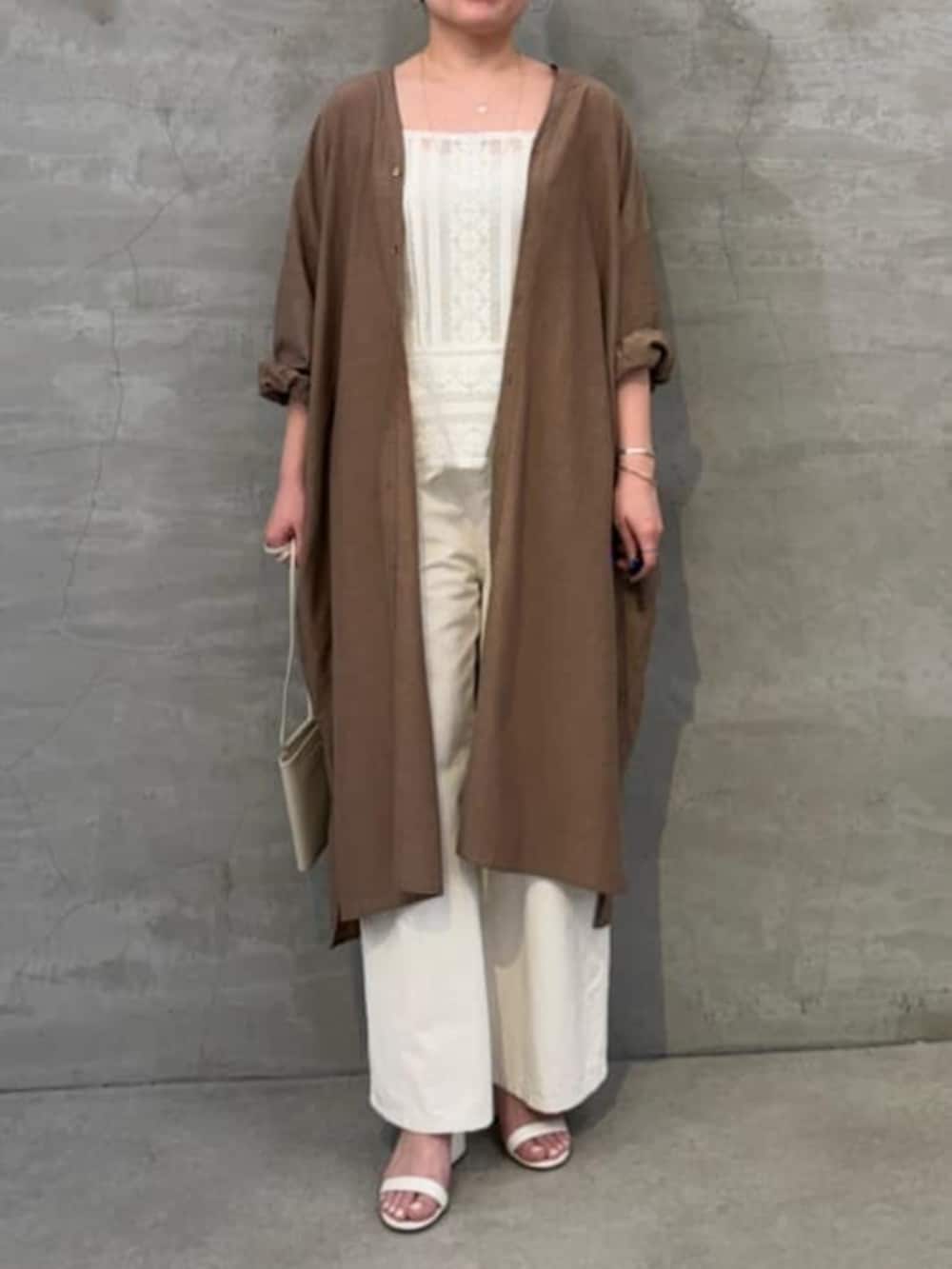 ホワイト系のショルダーバッグ、ホワイト系のシャツ/ブラウス、ベージュ系のワンピースを着用したレディースの冬コーディネートの5枚目の写真